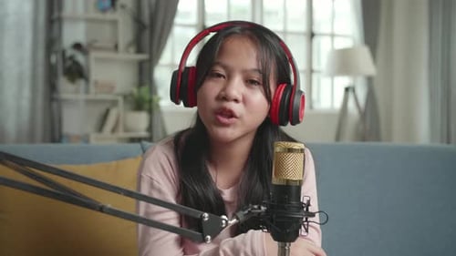 Chica vloguera asiática cantando mientras transmite. El niño está transmitiendo en vivo por Internet