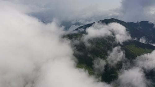 Aerial view: Fog covering a mountain hill. Beautiful Morning mist in the mountains