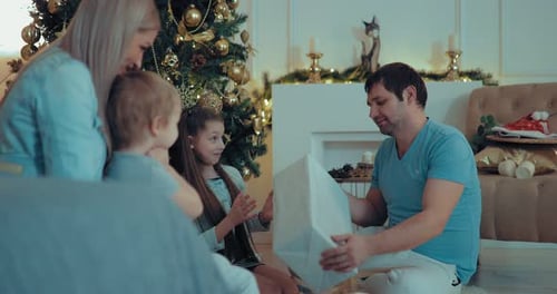 Dad and Daughter Open a New Year's Gift