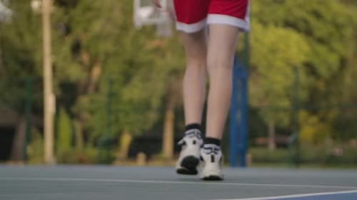 Child Athlete Dribbling Basketball on Outdoor Court