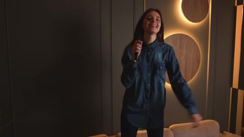 Young Woman Dancing and Singing with Remote Control