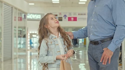 Happy Little Girl Pointing at Kids Store, Shopping at the Mall with Her Father