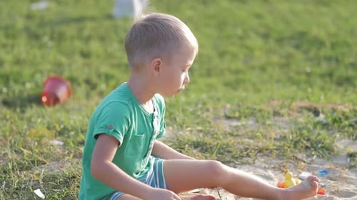 Young Child Playing with Toys in Sand