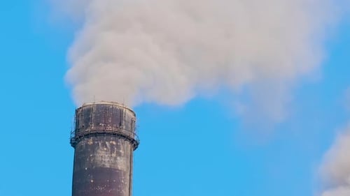 Closeup of Thermal Power Plant High Pipes with Black Smoke Moving Upwards Polluting Atmosphere