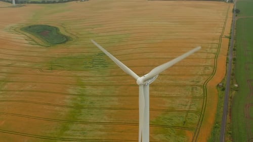 VUE AÉRIENNE : Éolienne qui tourne sous la force du vent et génère de l'énergie renouvelable dans un environnement