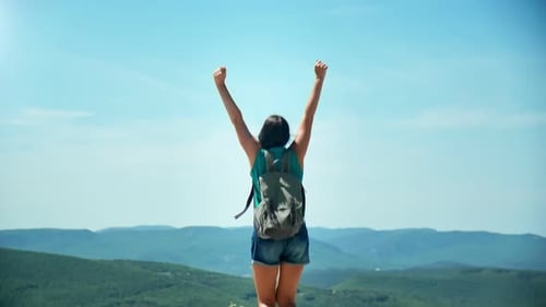 Joyful Woman Jumping on Top of Mountain Celebrating Victory
