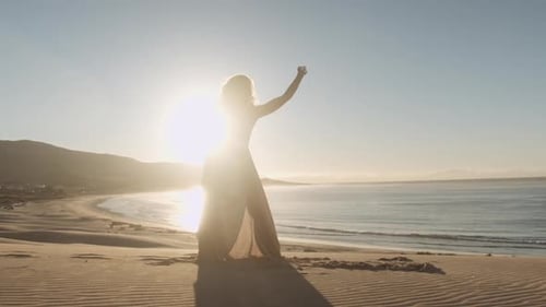 Dancer In Long Dress Performing On Sandy Beach