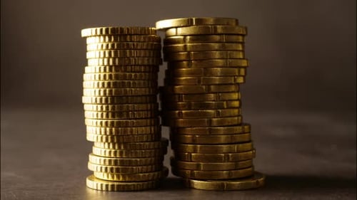 Gleaming Stacks of Gold Coins on Dark Surface