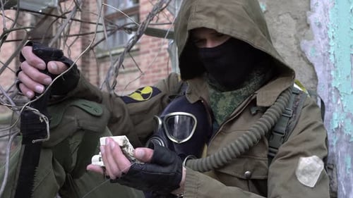 Männlicher Soldat oder Stalker vor dem Hintergrund eines zerstörten Gebäudes