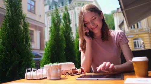 Young Woman Using Tablet Pc in a Cafe on a Summer Terrace