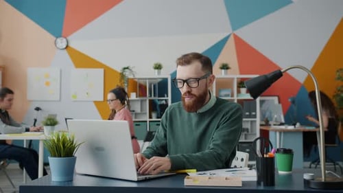 Slow Motion of Serious Businessman Working with Laptop in Open Space Office