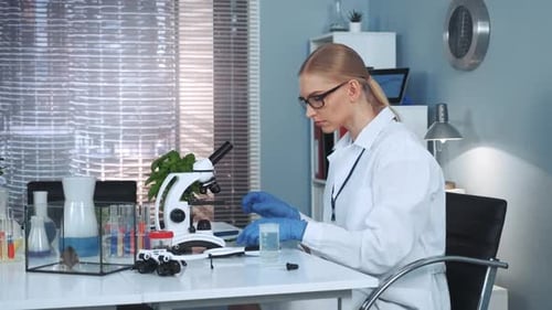 Young Woman Scientist Works in a Laboratory