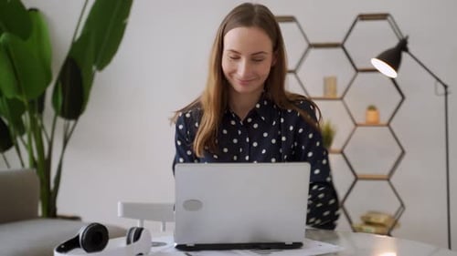 Woman Celebrating Success at Desk With Laptop