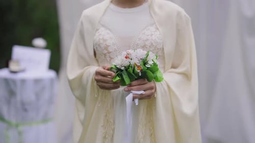 Bride Holding Flower Bouquet at Outdoor Wedding