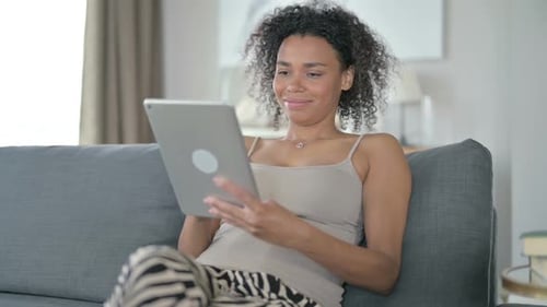 Woman Relaxes at Home Using Tablet