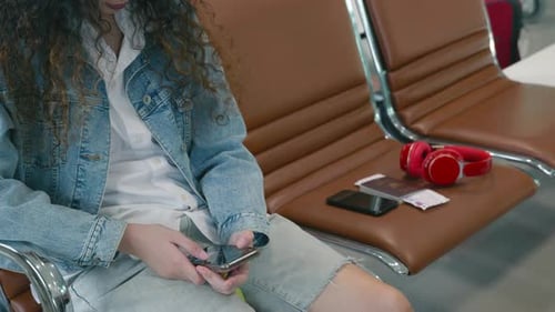 Passenger traveler woman in airport gate play smartphone for waiting air vacation travel