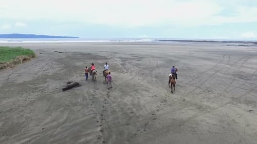 Family Riding Horses on the Seashore