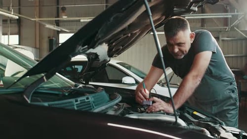 Mechanic Repairs Car in Commercial Garage
