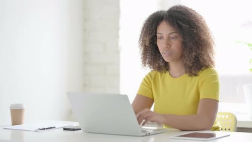 African Woman Thinking while using Laptop