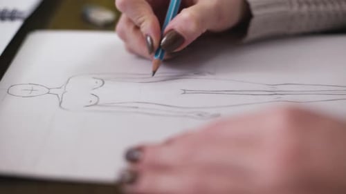 Woman Drawing Fashion Design Sketch with Pencil