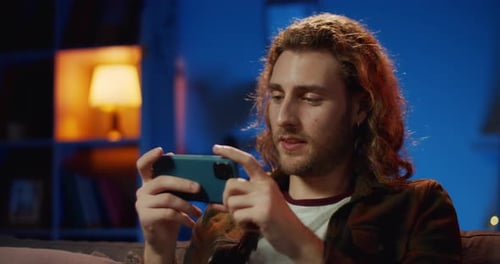 Young Adult Using Smartphone Indoors at Night