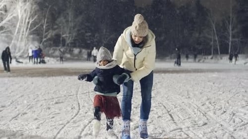 Kleines Mädchen beim Eislaufen mit Mutter