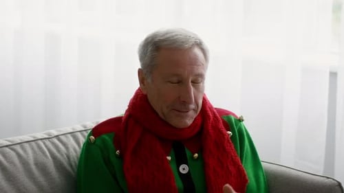 Senior Man in Elf Costume Sneezing Indoors