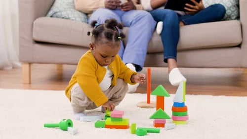 Cute Child Plays with Colorful Wooden Blocks at Home