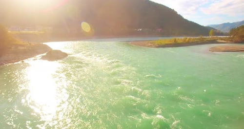 Low Altitude Flight Over Fresh Fast Mountain River with Rocks at Sunny Summer Morning.