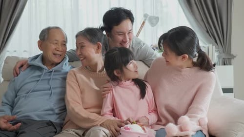 Multigenerational Family Smiling on Couch Together Indoors