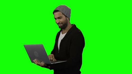 Man Smiling While Working on Laptop on Green Screen