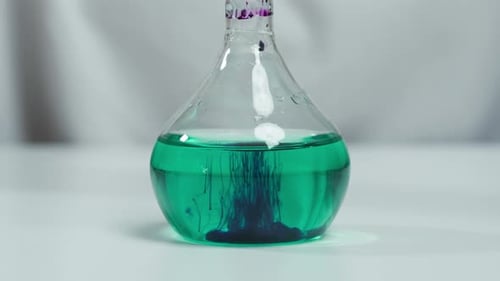 Adding Purple Powder Into Flask with Green Solution Closeup Making a Mixture