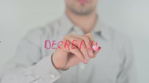 Man Writes the Word Decrease on Glass