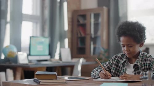 Boy Studying and Writing at Table