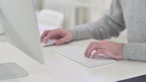 Nahaufnahme eines Mannes, der bei der Arbeit auf der Tastatur schreibt