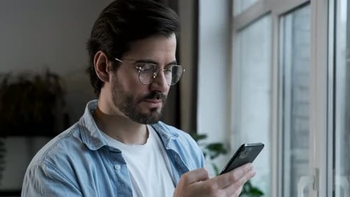Young Man Using Smartphone Indoors During the Day