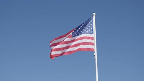 American Flag Waving Against Blue Sky