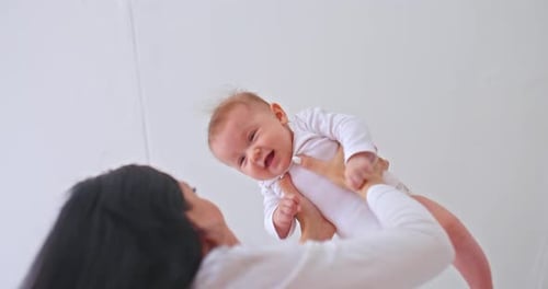 Mother Holds Up Adorable Smiling Infant