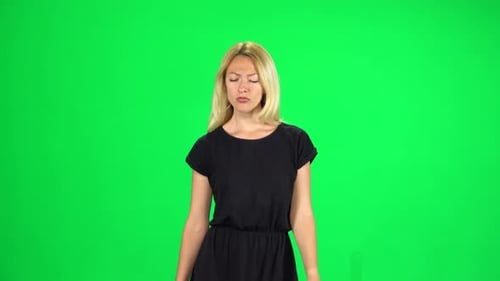Pensive Girl Is Walking on a Green Screen at Studio.