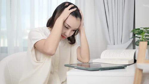 Woman Using Tablet Device at Home Feeling Stressed