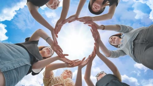 Friends Make a Circle From Their Palms Against the Background of a Fabulous Sky