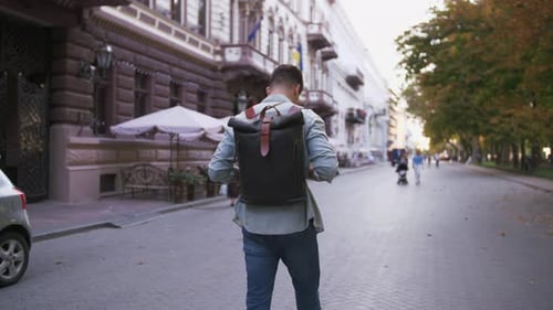 Attractive Young Handsome Man Tourist with Backpack Walking in City Center Slow Motion