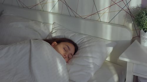 Woman Sleeps Peacefully in Bright Bedroom