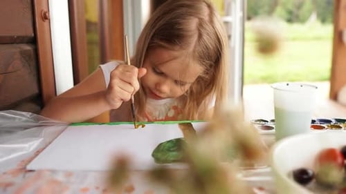 A Little Girl Painting Outdoors