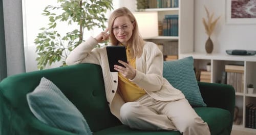 Woman Using Tablet on Sofa at Home