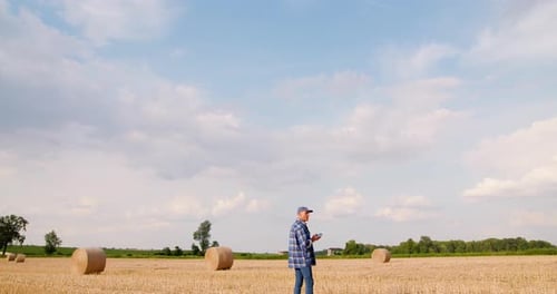 Farmer Using Digital Tablet While Examining Field