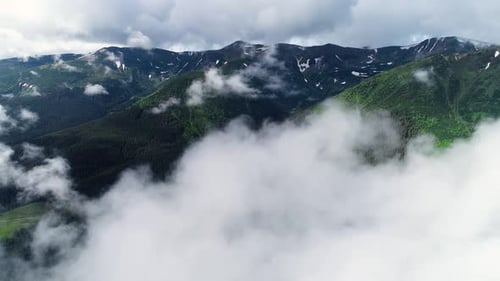 Flying Through the Clouds Above Mountain Tops. High Peaks with Forest, Wonderful Natural Landscape