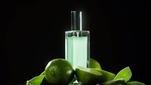 Perfume Bottle with Fresh Limes and Leaves