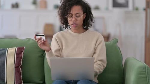 Online Shopping Failure on Laptop By African Woman on Sofa