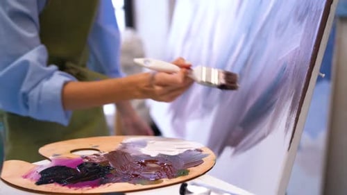 Artist Painting on Canvas with Paint Brush